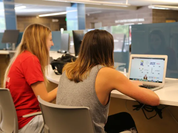 students with laptop at tech bar