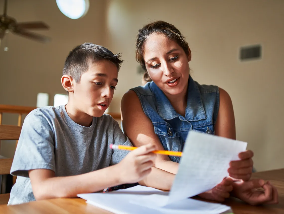 A boy doing homework with his mother