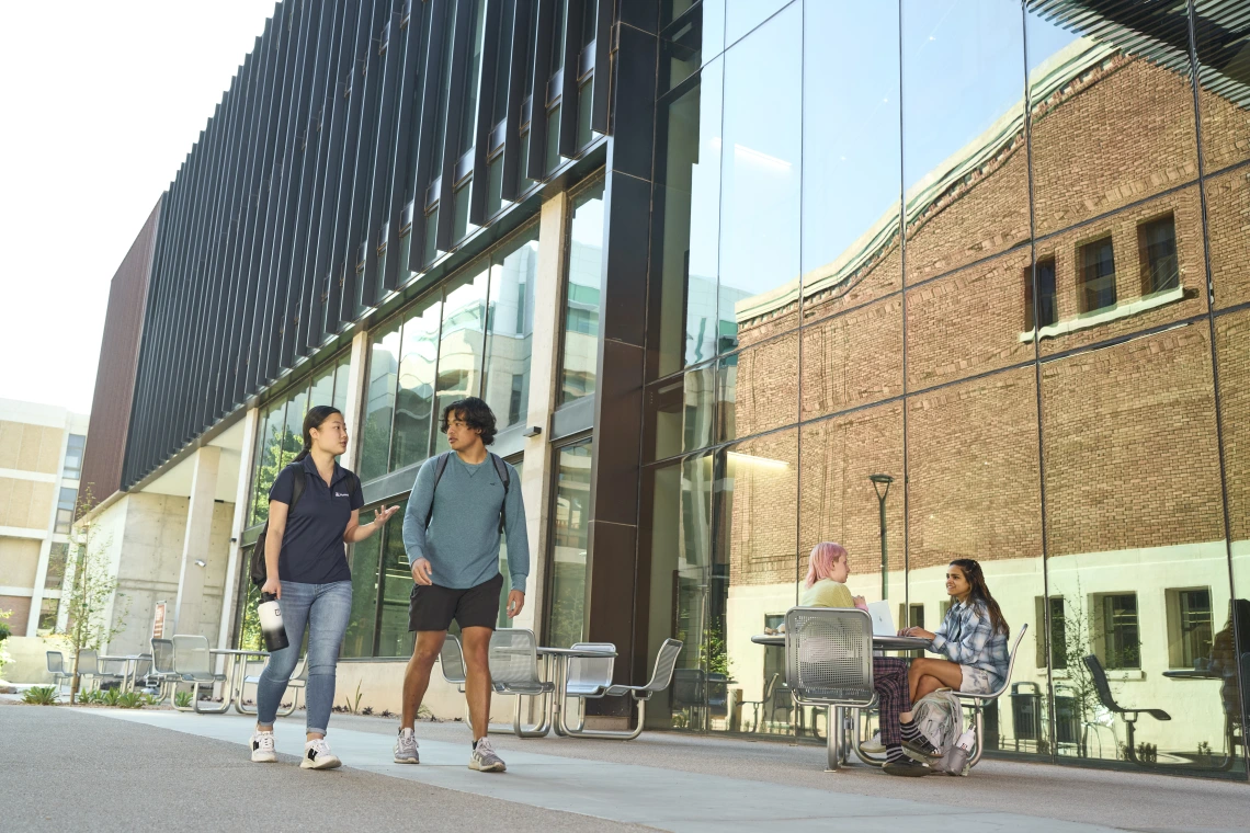 Students walking outside next to a building