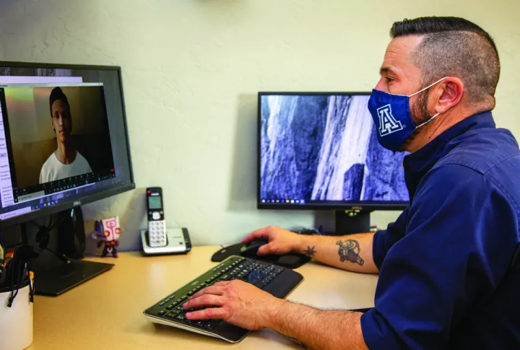 A person using a computer to attend a virtual meeting