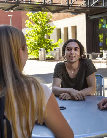 Two people sitting across a table in conversation