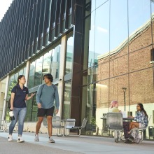 Students walking outside next to a building